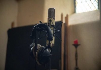 Casque pour écouter de la musique posé un micro, éclairés par le soleil à travers un vitrail