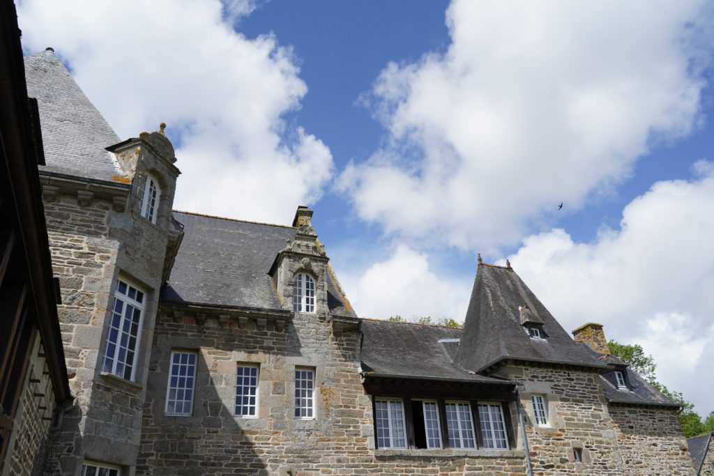 Château de brélidy vu en contre plongé, des hirondelles passent dans le ciel